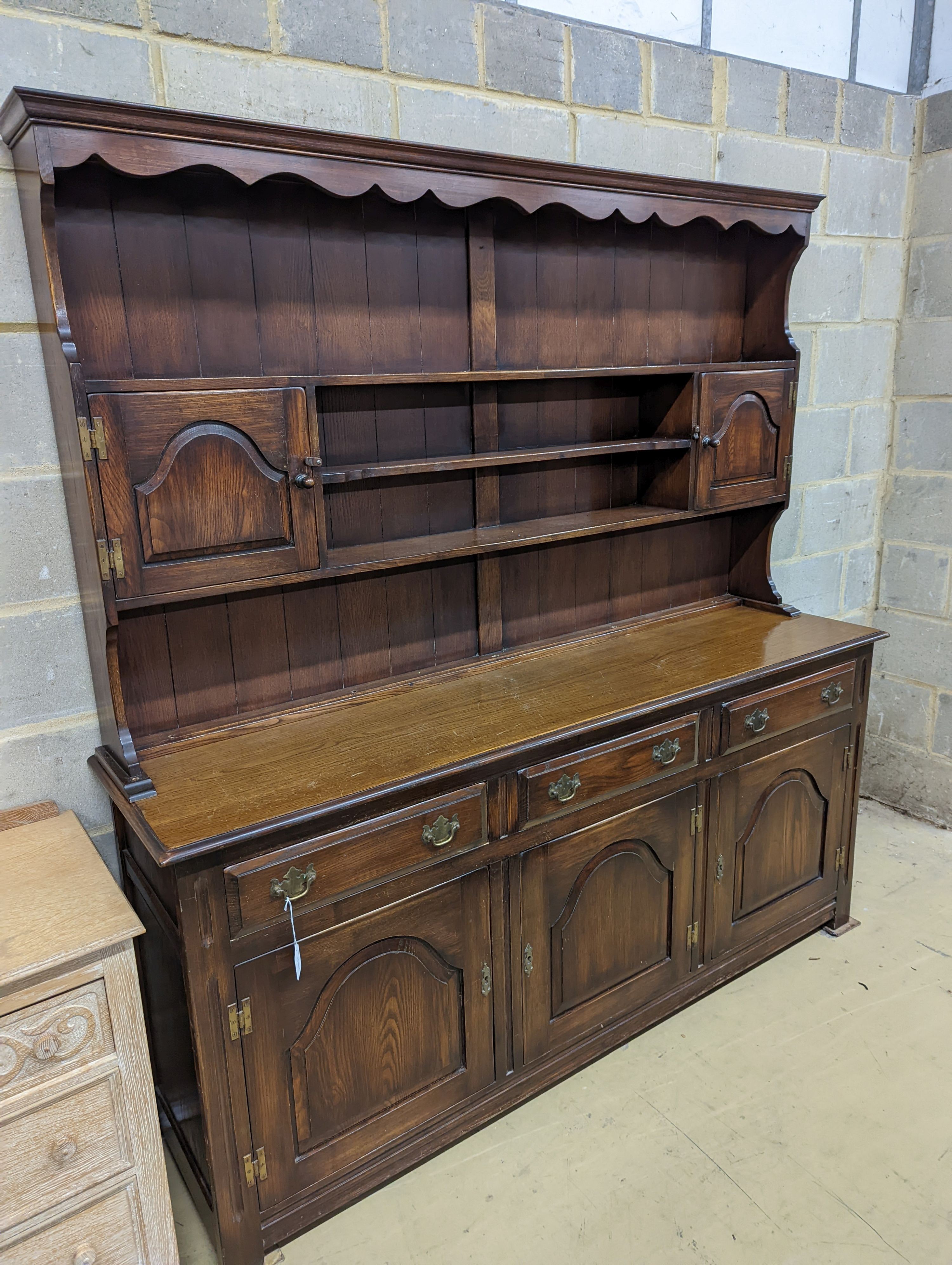 A Georgian style oak dresser base with boarded rack, W-184cm, D-46cm, H-188cm.